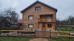 Log cabin house with fireplace and countryside surroundings
