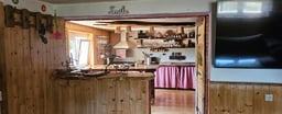 Log cabin house with fireplace and countryside surroundings